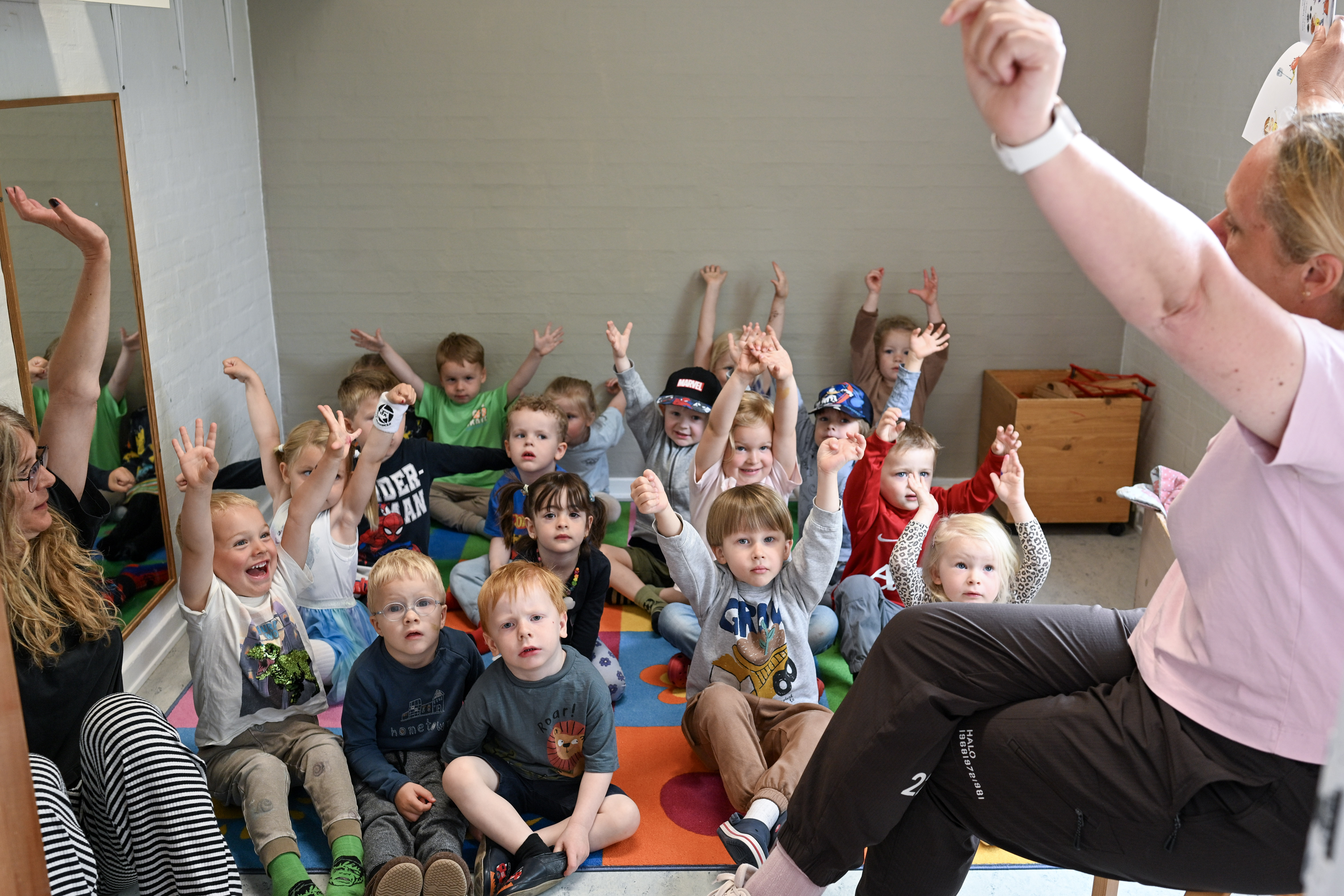 Børn og voksne holder samling